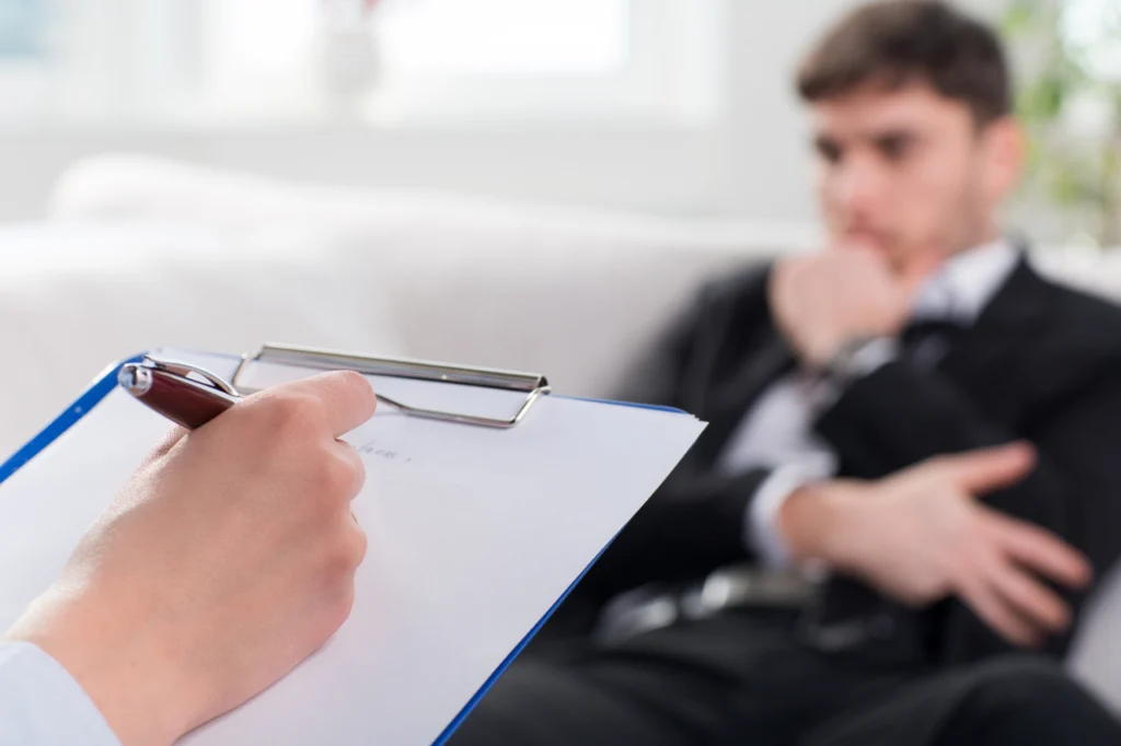 A doctor takes notes during a consultation with a patient
