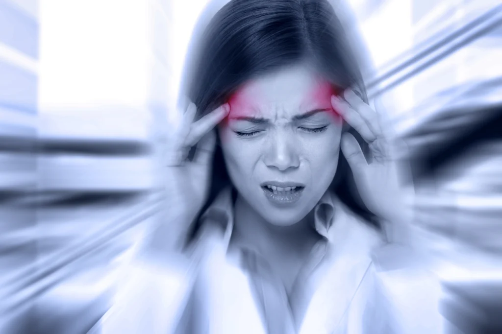 A woman grips her head as it throbs with pain
