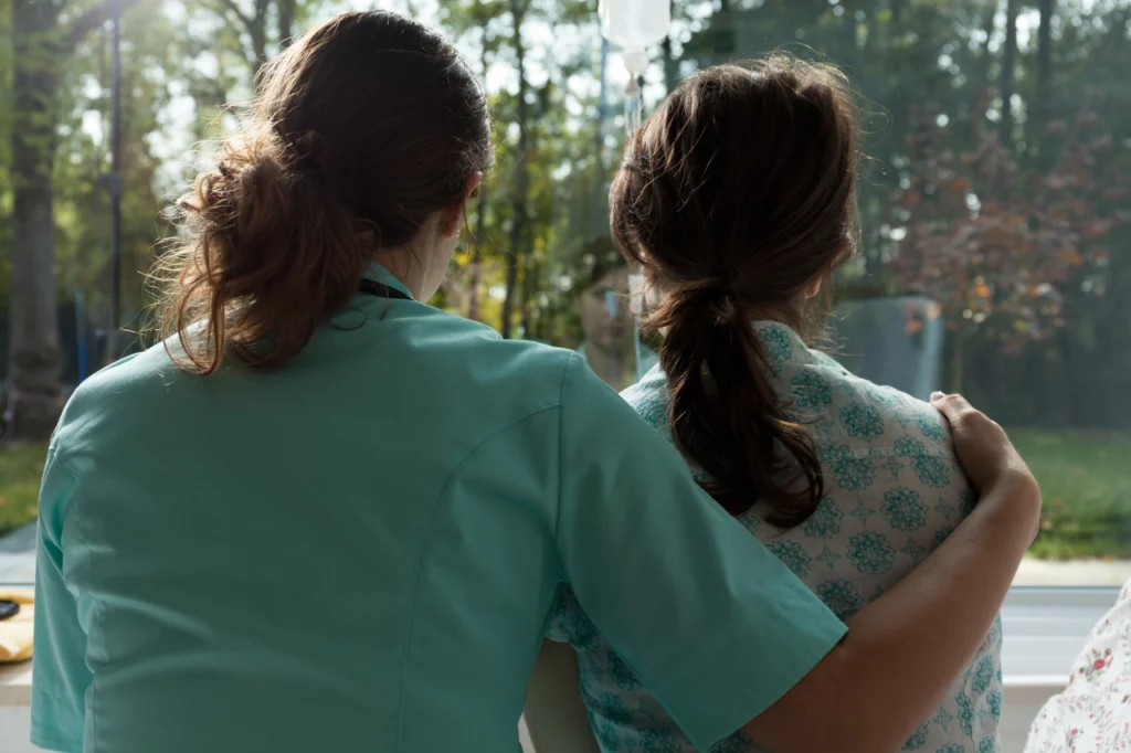 A doctor reassures a patient by gripping their shoulder