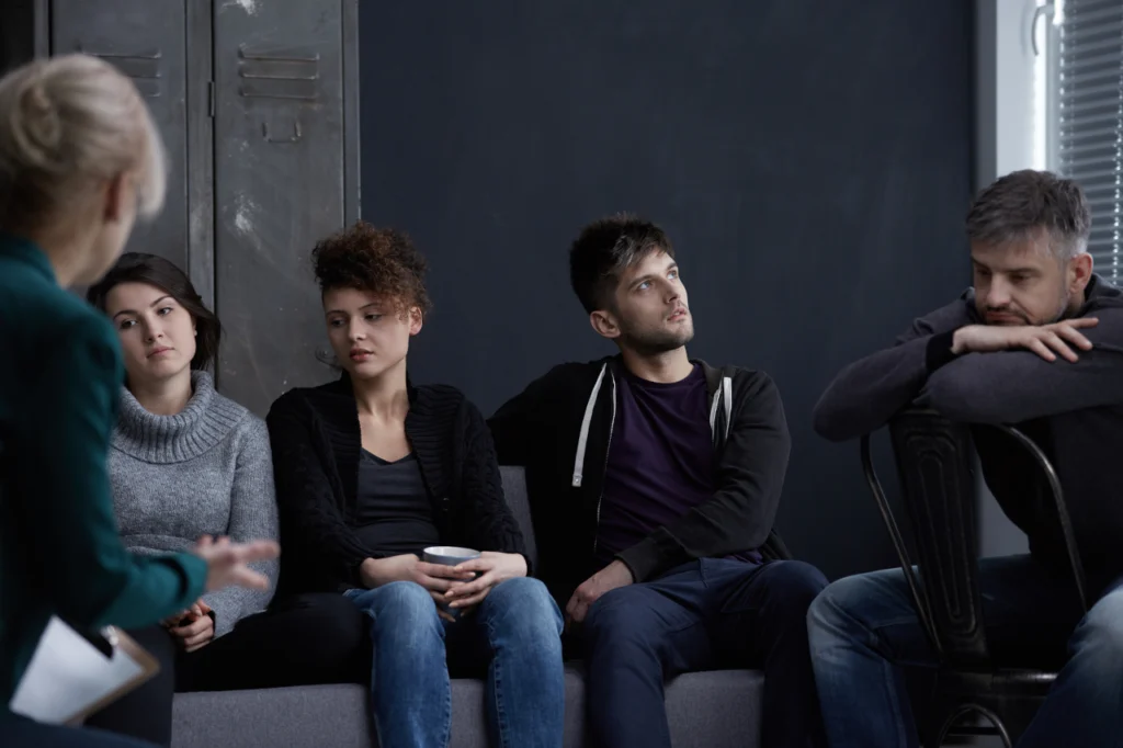 People sit next to each other in an addiction recovery support group