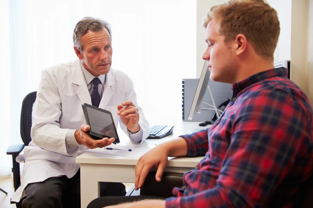 A doctor explains something to a man during a consultation
