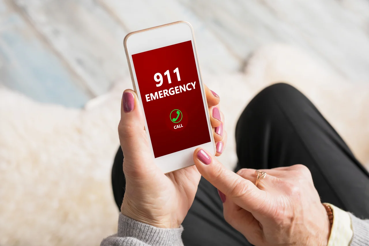 A person dials 911 on their phone. Learn more about emergency and mental health crisis phone numbers here.