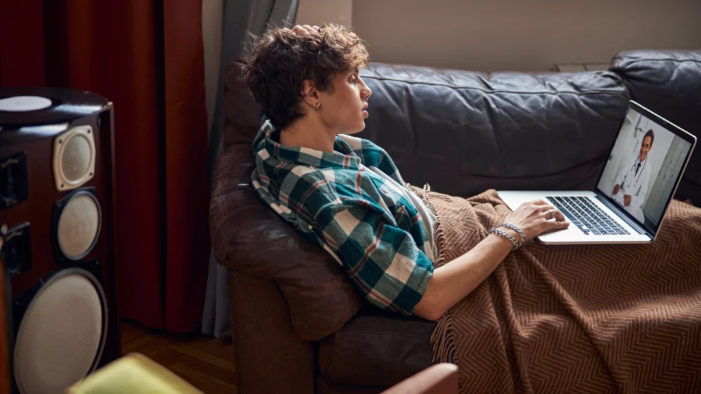 A young man speaks with a doctor during a telehealth session