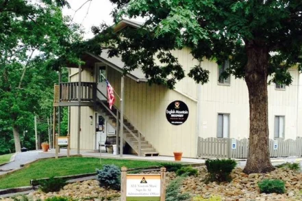 Exterior view of English Mountain Recovery facility showing main entrance with landscaped grounds, trees, and facility signage