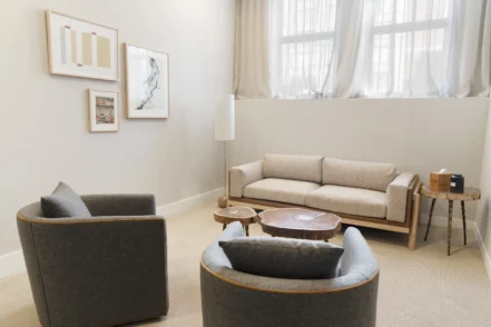 Interior lounge space with modern seating arrangements, coffee tables, and large windows providing natural light